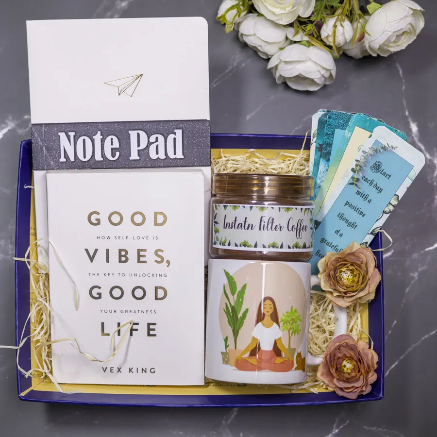 Serene Wellness Bundle featuring a white notepad, Vex King's "Good Vibes, Good Life" book, a yoga-themed mug, premium instant coffee, handmade bookmarks, and a reusable designer tray arranged aesthetically.