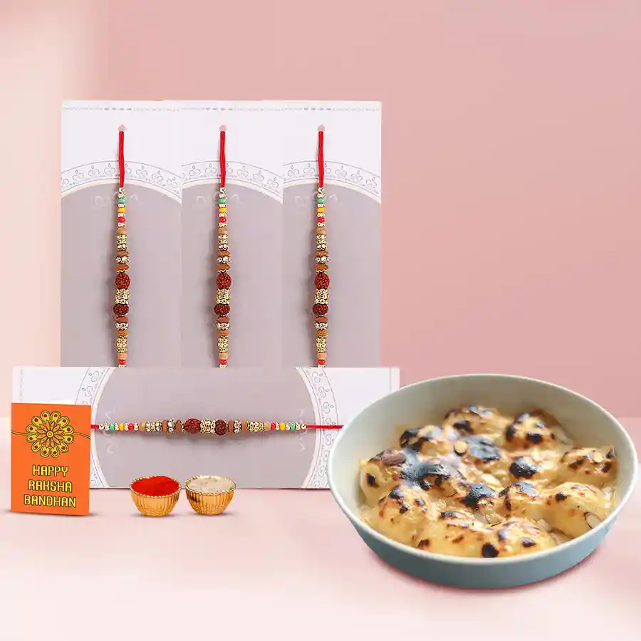 Baked Rasgulla arranged on a platter with a set of four Rudraksha Rakhis, Roli Chawal Tika, and a Rakhi Wishes Card, celebrating Raksha Bandhan