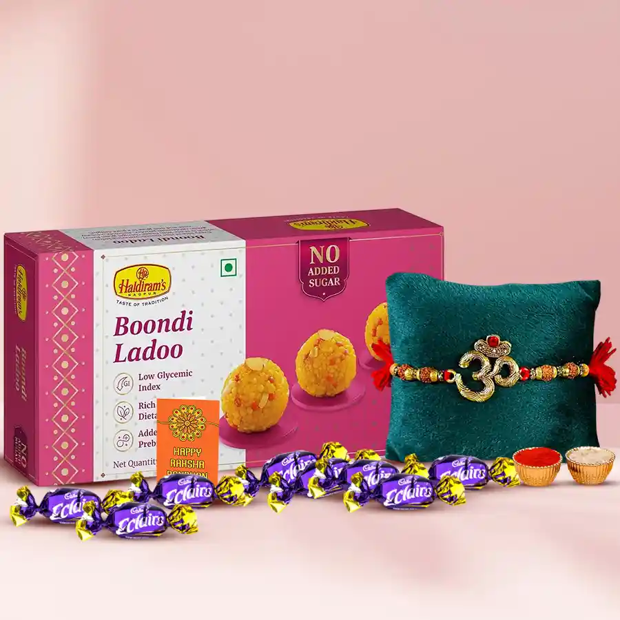 Dashing Om Rakhi with Haldiram sweets and Cadbury Eclairs, including Roli Tilak, Chawal, and a personalized card, presented in a festive arrangement.