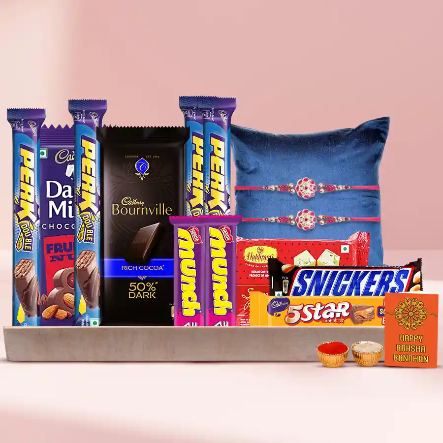Chocolate Binge With Rakhi Pair featuring assorted chocolates, two beautiful Rakhis, traditional Roli, Tika, Chawal, Haldiram Soan Papdi, and elegantly arranged in a reusable wooden tray.