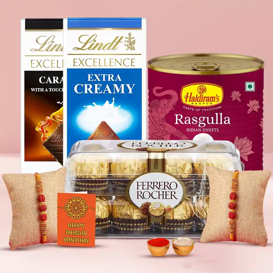 Chocolaty Charm with Twin Rakhi hamper featuring Lindt Chocolate Bars, Ferrero Rocher chocolates, Haldiram Rasgulla, and Twin Rudraksha Rakhi with Roli, Tika, and Chawal.