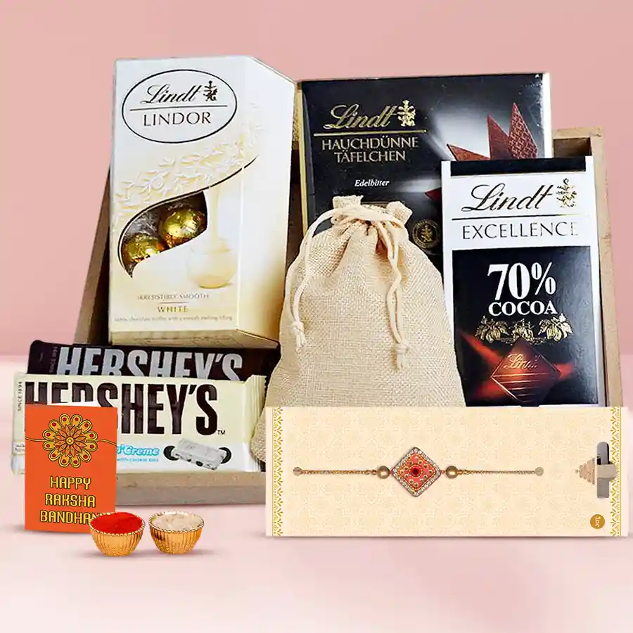 Festive gift set for Raksha Bandhan featuring Rakhi, Lindt and Hershey’s chocolates, crunchy almonds in a jute potli, traditional Roli, Tika, Chawal, all presented on a reusable wooden tray.