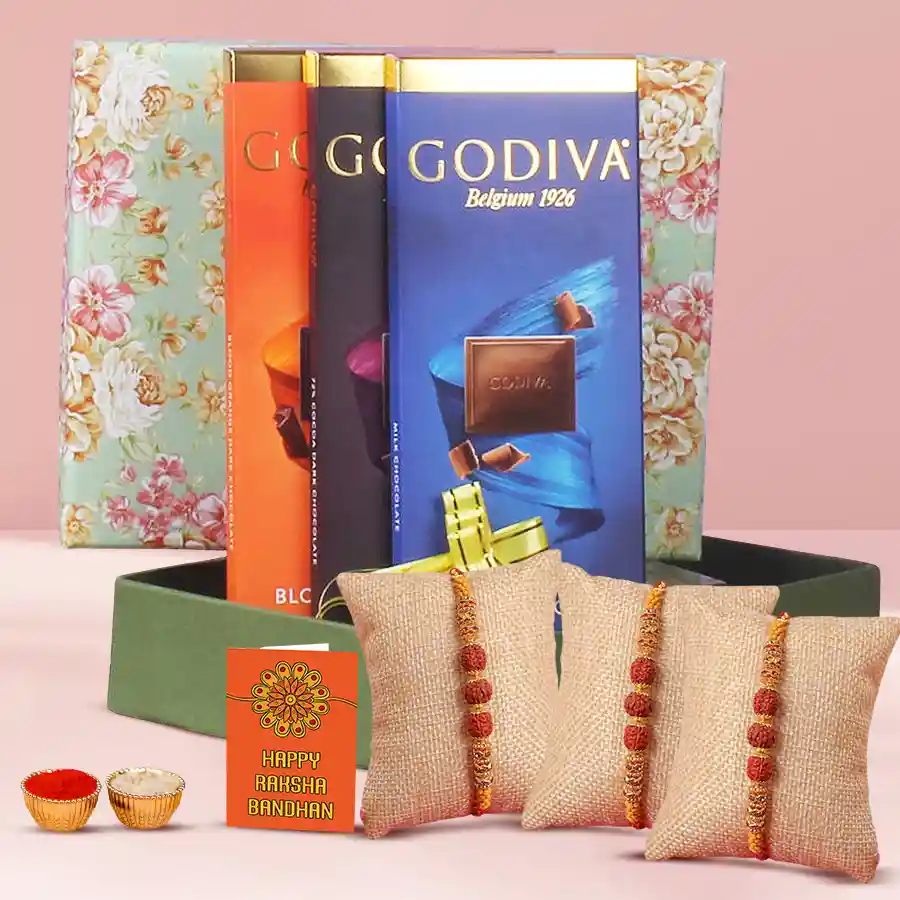 Finest Godiva and Rudraksha Rakhi Set with 3 rakhis and 3 Godiva bars, accompanied by Roli, Tilak, and Chawal for Raksha Bandhan celebration.
