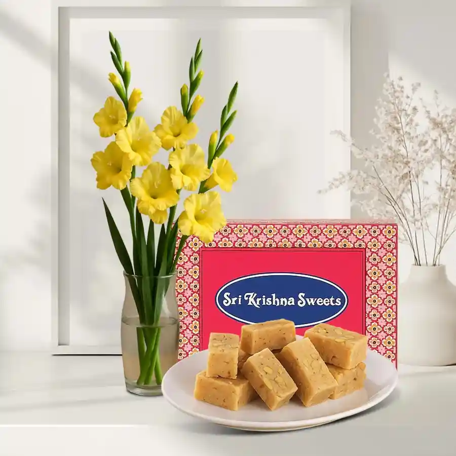 Bright yellow gladiolus arranged in a glass vase with Mysore Pak treat.