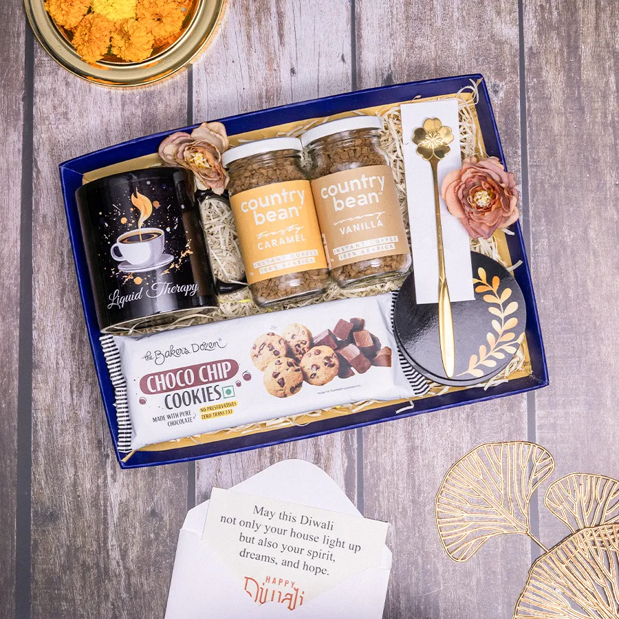 Coffee Bliss Diwali Hamper featuring a coffee mug, instant coffee packs, choco chip cookies, coasters, a golden spoon, and a reusable basket.