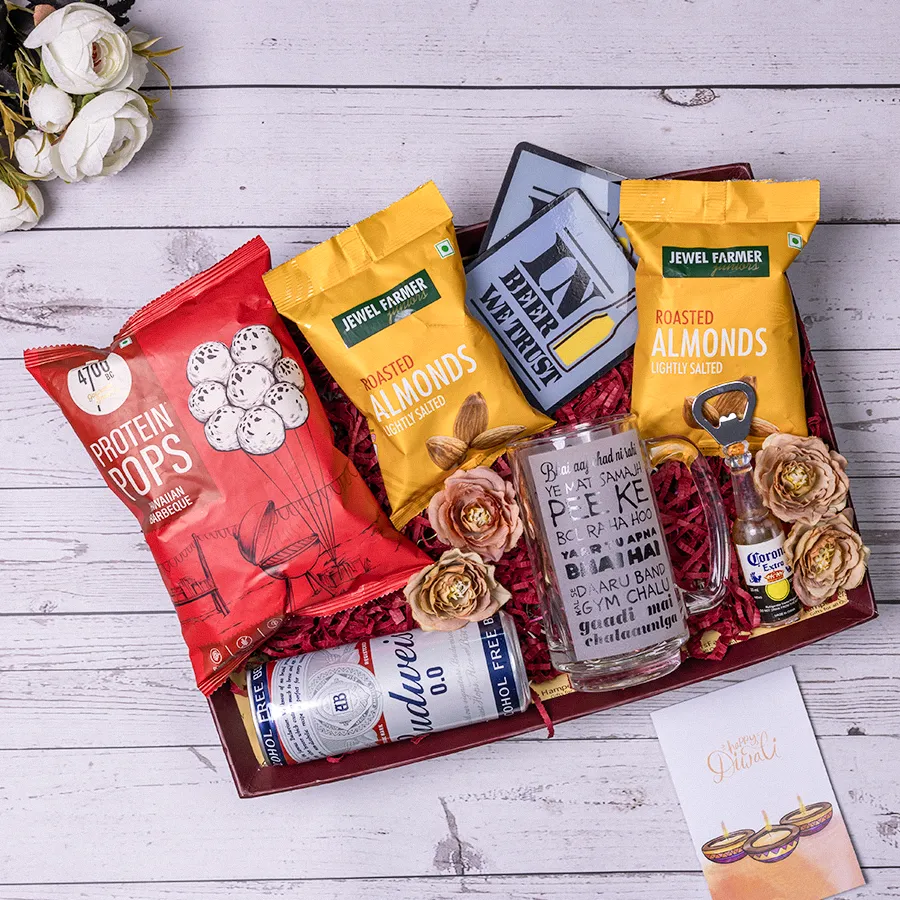 Beer Enthusiasts Delight Hamper featuring non-alcoholic beer, a humorous beer mug, a bottle opener, coasters, protein pops, and roasted almonds arranged in a reusable basket.