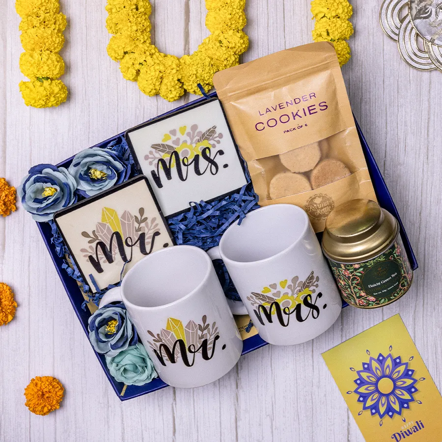 Couples tea gift hamper featuring Lavender Cookies, Couple Mug set, coasters, and Elaichi Green Tea in a reusable basket