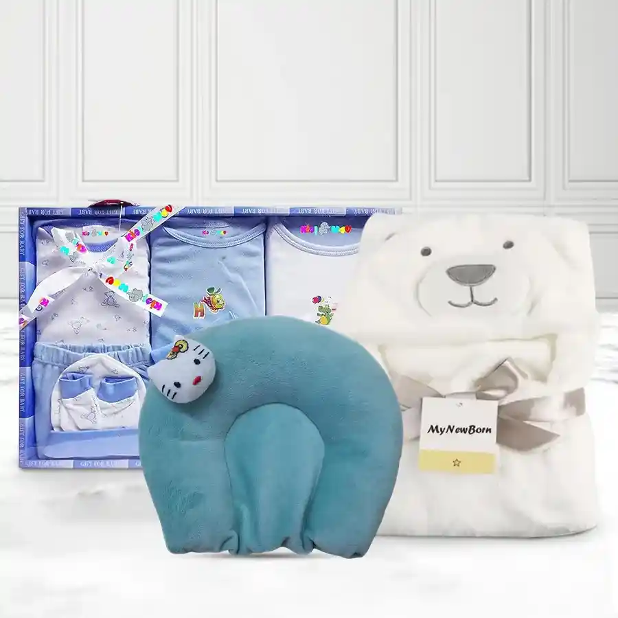 Adorable baby clothing set featuring a blue dress set, a white cartoon-patterned wrapper blanket, and a sea-green neck supporting pillow.