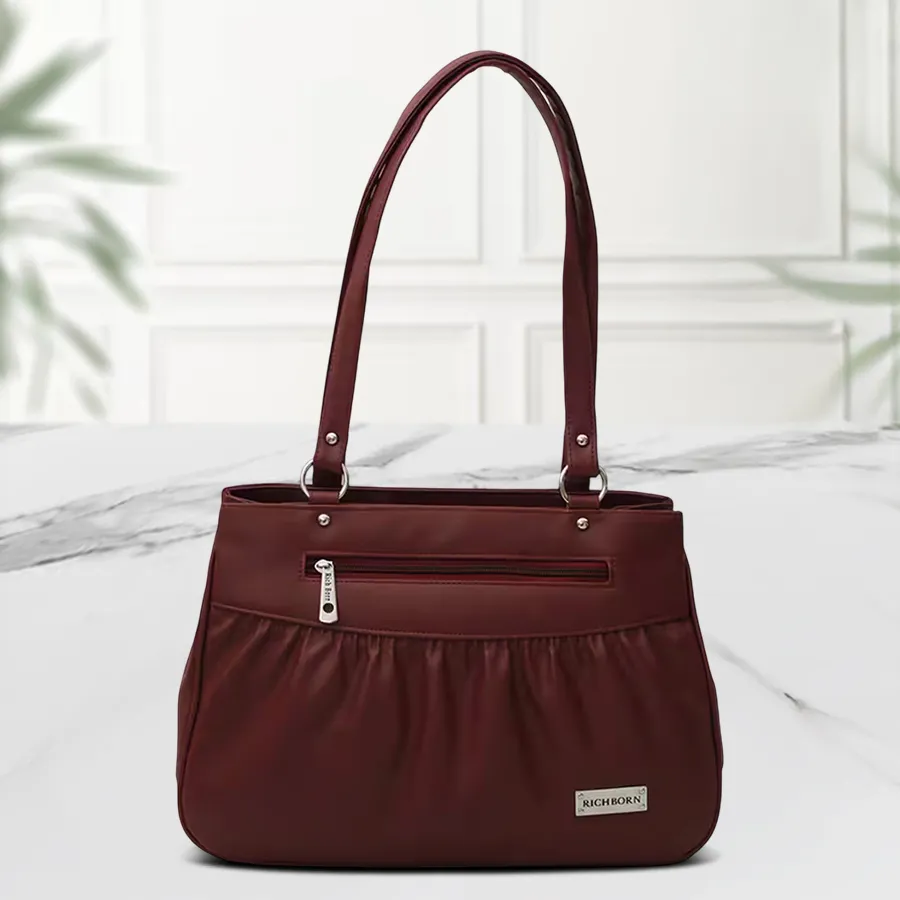 Deep maroon shoulder bag with front stitches designed for women, featuring two chambers and crafted from faux leather.