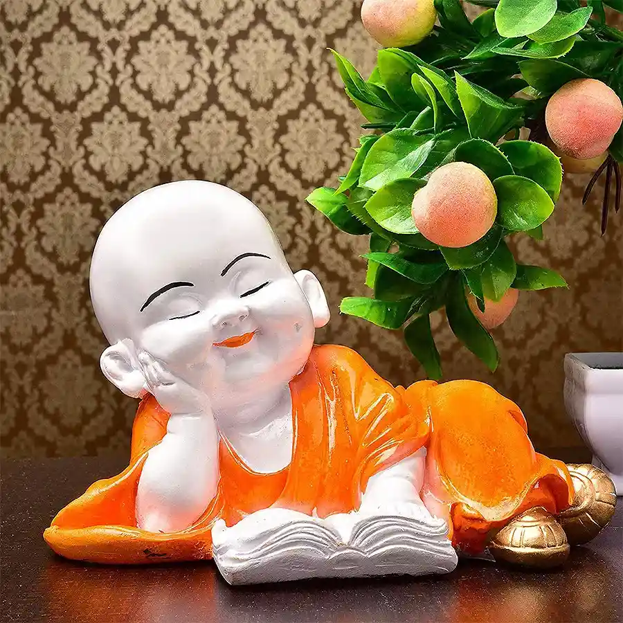 Orange polyresin Monk Buddha reading book showpiece, a symbol of tranquility and wisdom, perfect for home decor or as a thoughtful gift.