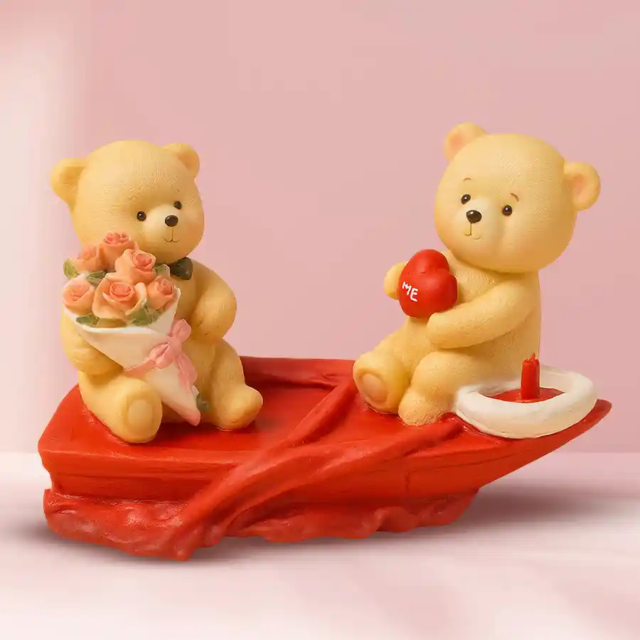 Twin Teddies in a Love Boat, one with a rose bouquet and the other with a love heart, symbolizing love and affection in a charming showpiece.
