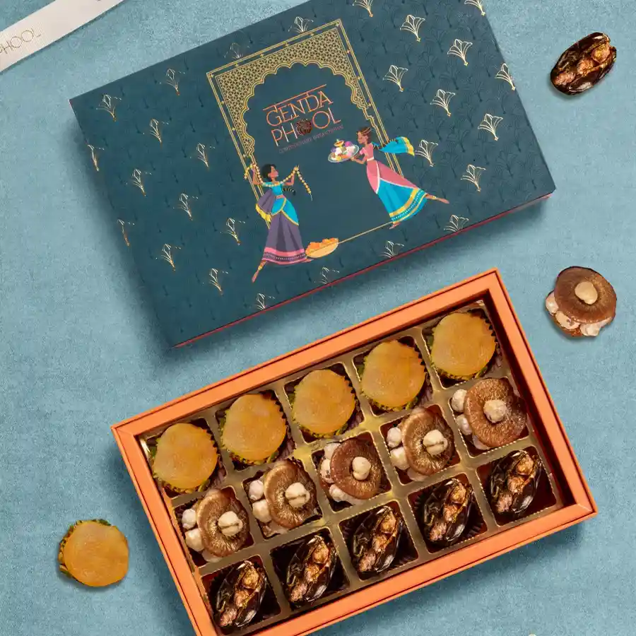 Golden Elegance Snack Box featuring stuffed medjool dates, apricots, and figs decorated with gold varq, emphasizing opulence and gourmet indulgence.