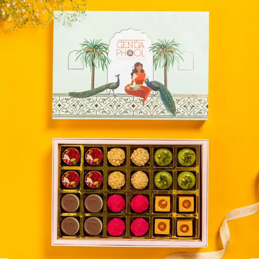 A beautifully arranged 24-piece box of assorted mithai including Earthy Bliss, Butterscotch, Gud Pistachio, Cashew Brew, Gram Rose Fudge, and Hazel Surprise.