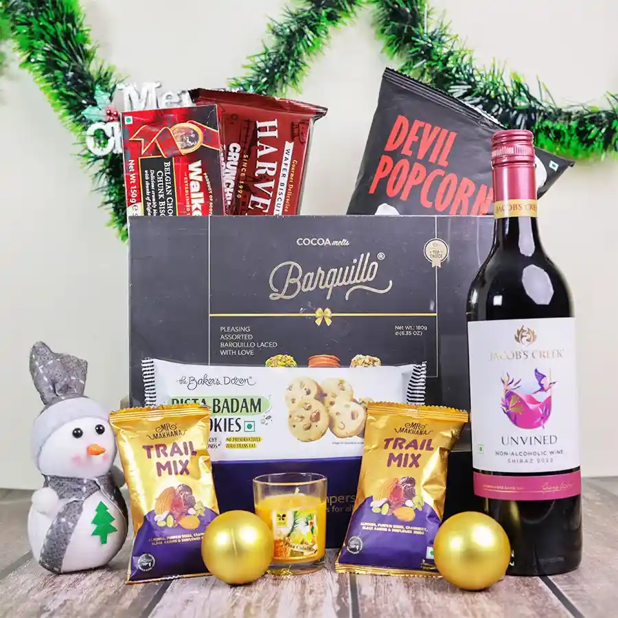A festive gourmet Christmas gift hamper filled with chocolates, cookies, spicy popcorn, and a non-alcoholic wine, all beautifully arranged in a reusable basket.