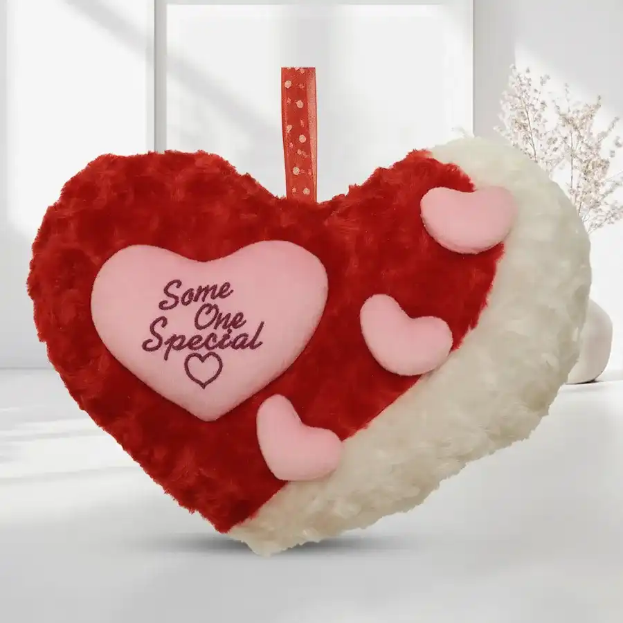Heart-shaped cushion with red and white pillows, featuring pink hearts, ideal for cozy home decor.