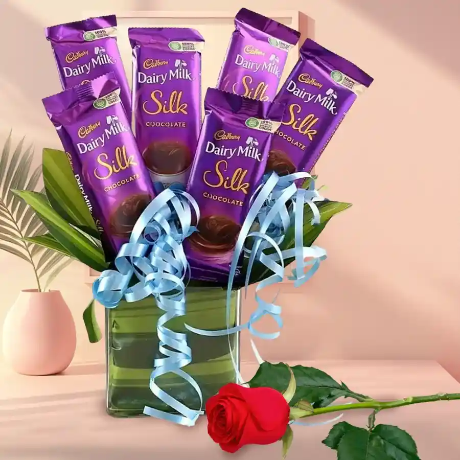 Exquisite gift set with Cadbury Dairy Milk Silk chocolates and a rose in a glass vase.