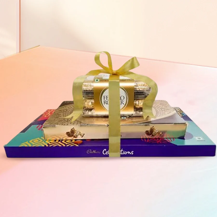 A beautifully arranged Towering Sweet Chocolate Delight featuring Ferrero Rocher chocolates and a Cadbury Celebration Box.
