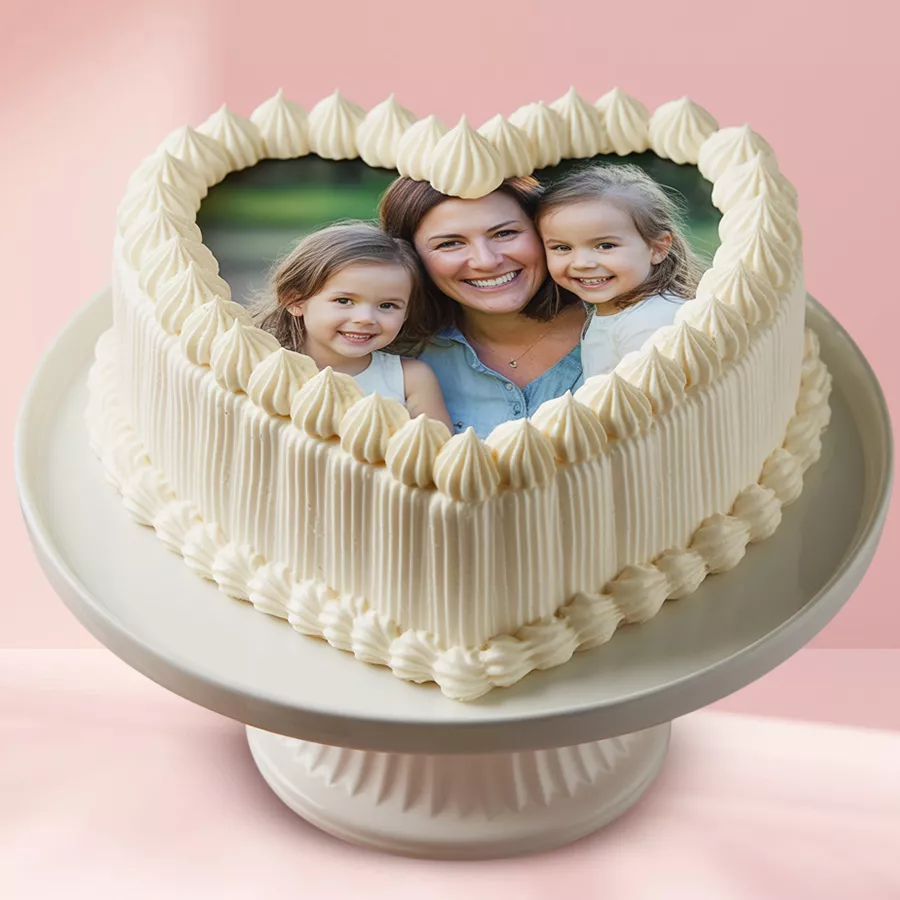 Heart-shaped eggless vanilla photo cake featuring a custom image on top, elegantly covered in white fondant.