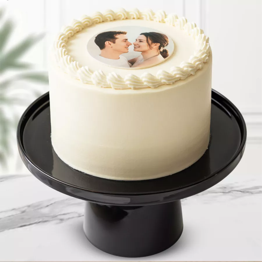 Round vanilla photo cake with white icing and personalized photo.