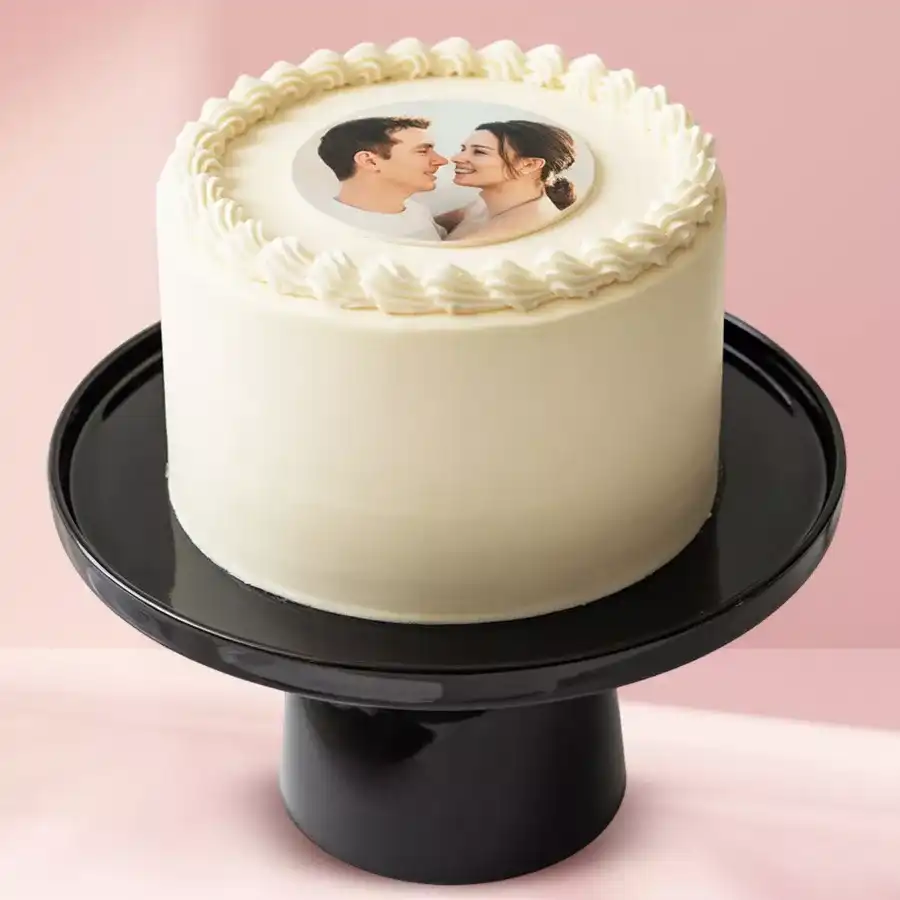 Eggless heart-shaped vanilla fondant cake topped with a personalized photo, perfect for celebrations.