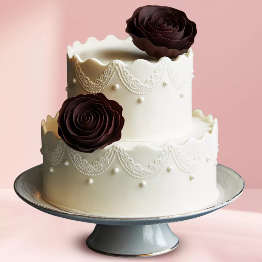 Two-Tier Vanilla Cake adorned with chocolate roses, perfect for celebrations.