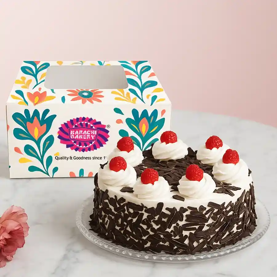 1 lb Black Forest Cake adorned with whipped cream, cherries, and chocolate shavings from Karachi Bakery.