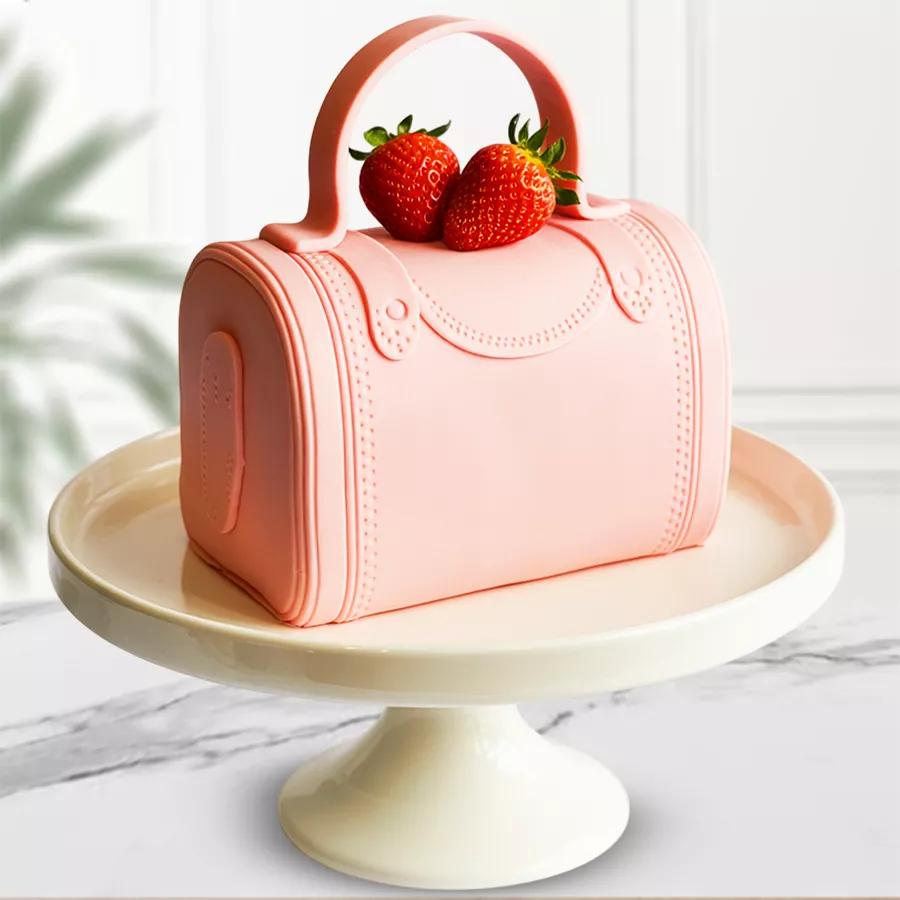 Whimsical Strawberry Cake shaped like a vanity bag, featuring fondant garnishing and a strawberry sponge base, weighing 3 Kg.