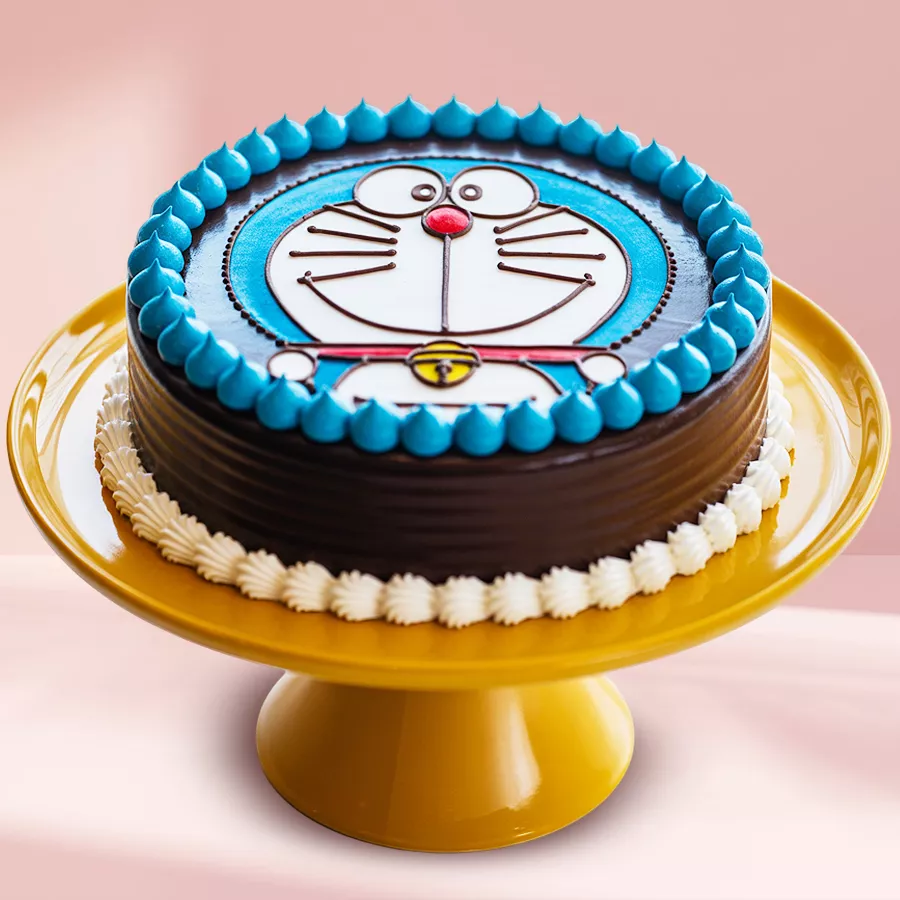 Round Doraemon-themed chocolate cake decorated with fresh whipped cream, perfect for kids' celebrations.
