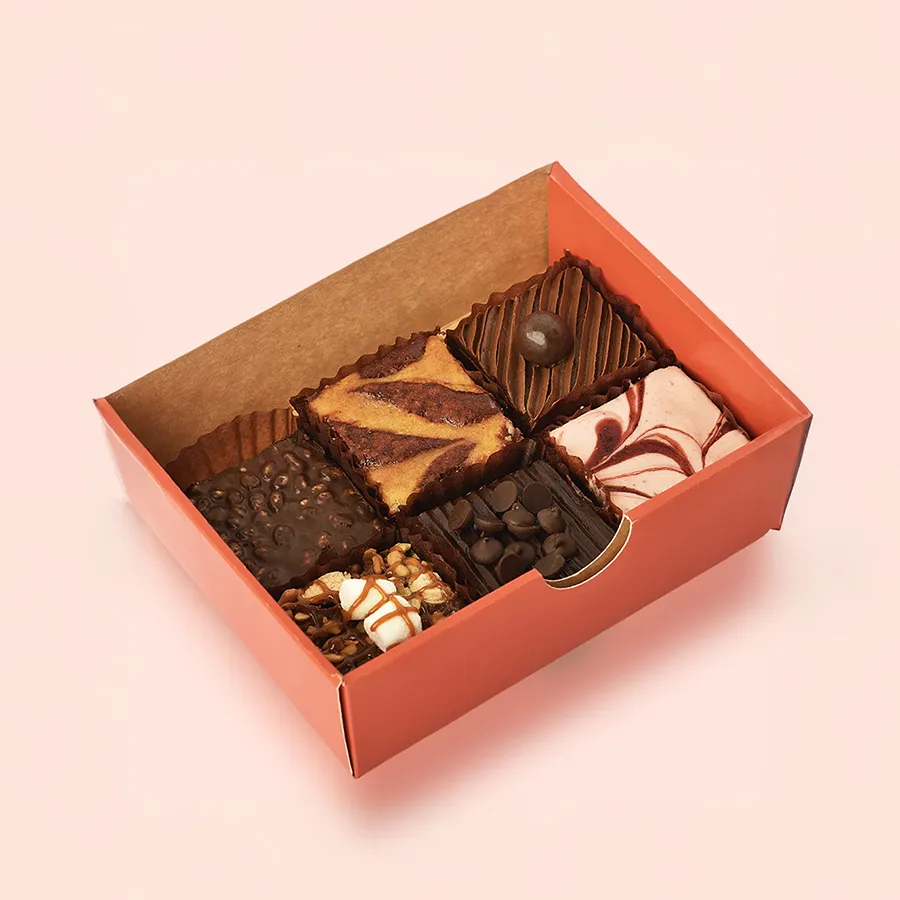 An assortment of six decadent brownies from Theobroma in an elegant package, showcasing a variety of flavors and textures.