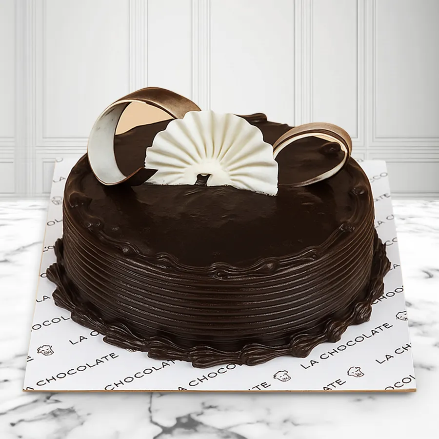 A luxurious truffle cake featuring dense chocolate layers and a silky ganache, perfect for celebrations or personal indulgence.