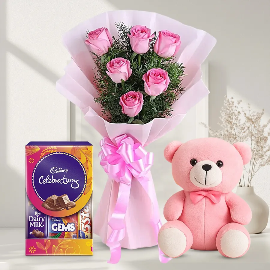 Charming gift set featuring pink roses, a small teddy bear, and chocolates.