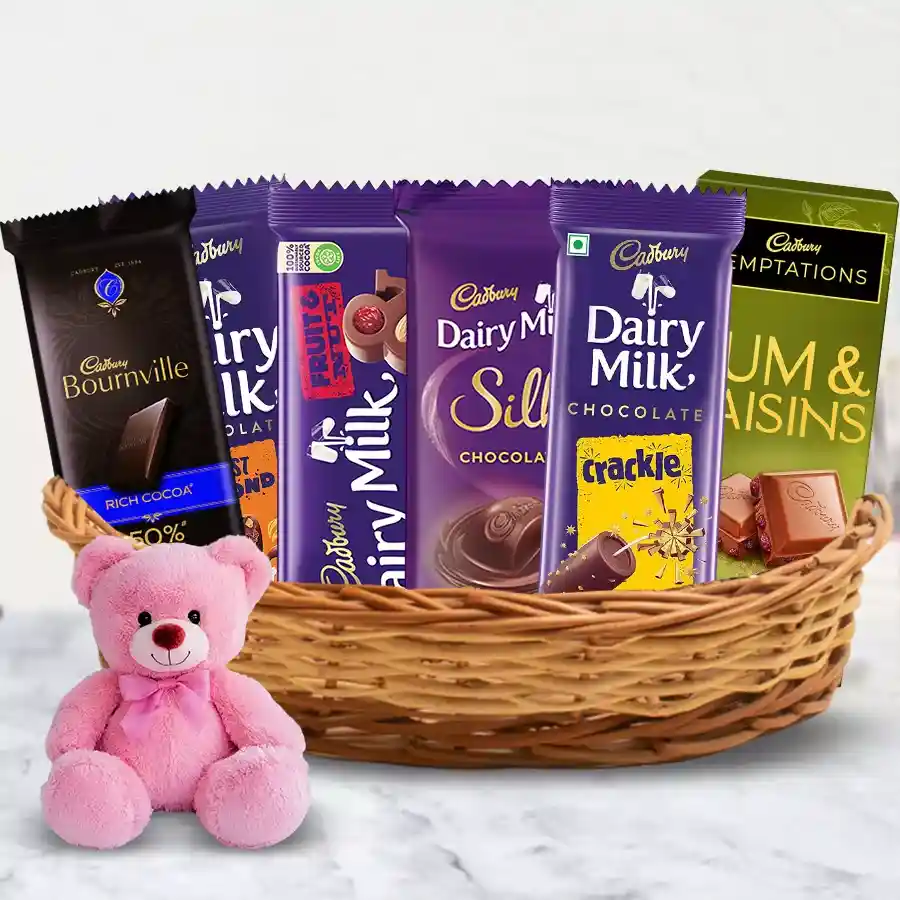 An attractive gift basket featuring assorted Cadbury chocolates and a small teddy bear, perfect for celebrating special moments.