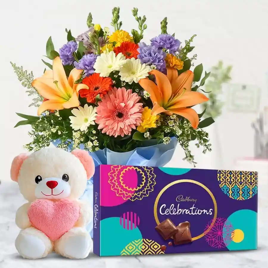 Whimsical bouquet of 12 mixed flowers with a teddy bear and Cadbury Celebrations pack.