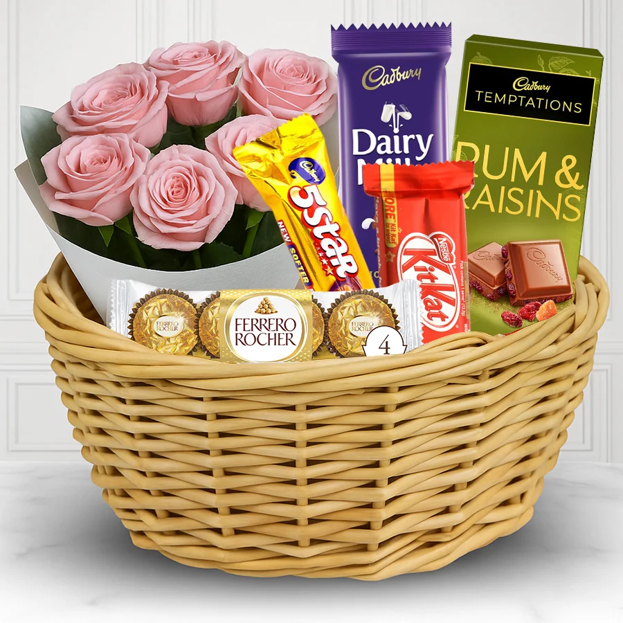 A joyful selection of pink roses paired with a chocolate gift hamper featuring Ferrero Rocher, 5 Star, Kit Kat, Cadbury Crackle, and Cadbury Temptation.