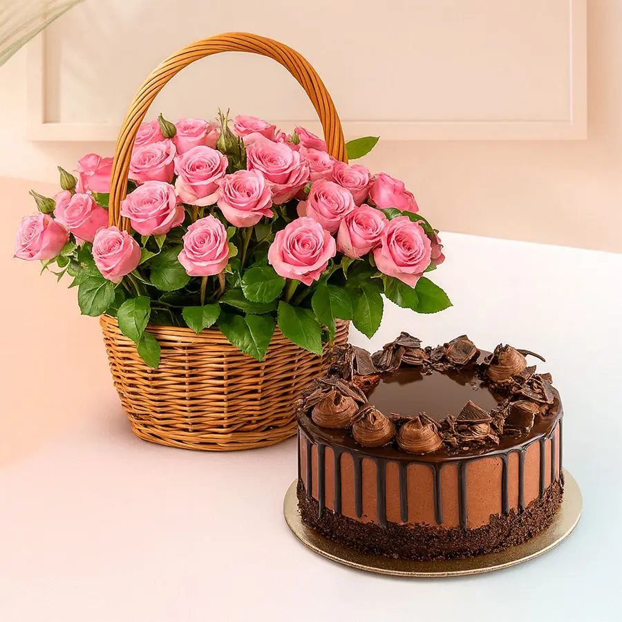 An elegant basket filled with 12 pink roses alongside a rich dark chocolate truffle cake.