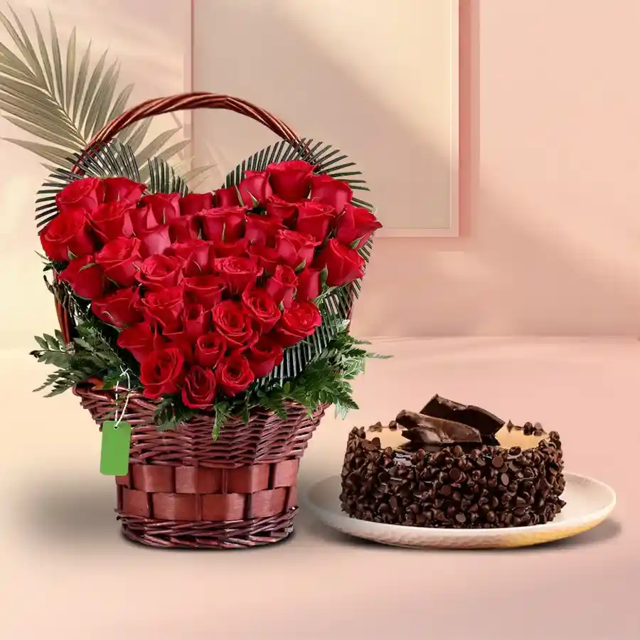 Heart-shaped basket with 50 red roses and round chocolate cake, symbolizing love and celebration.