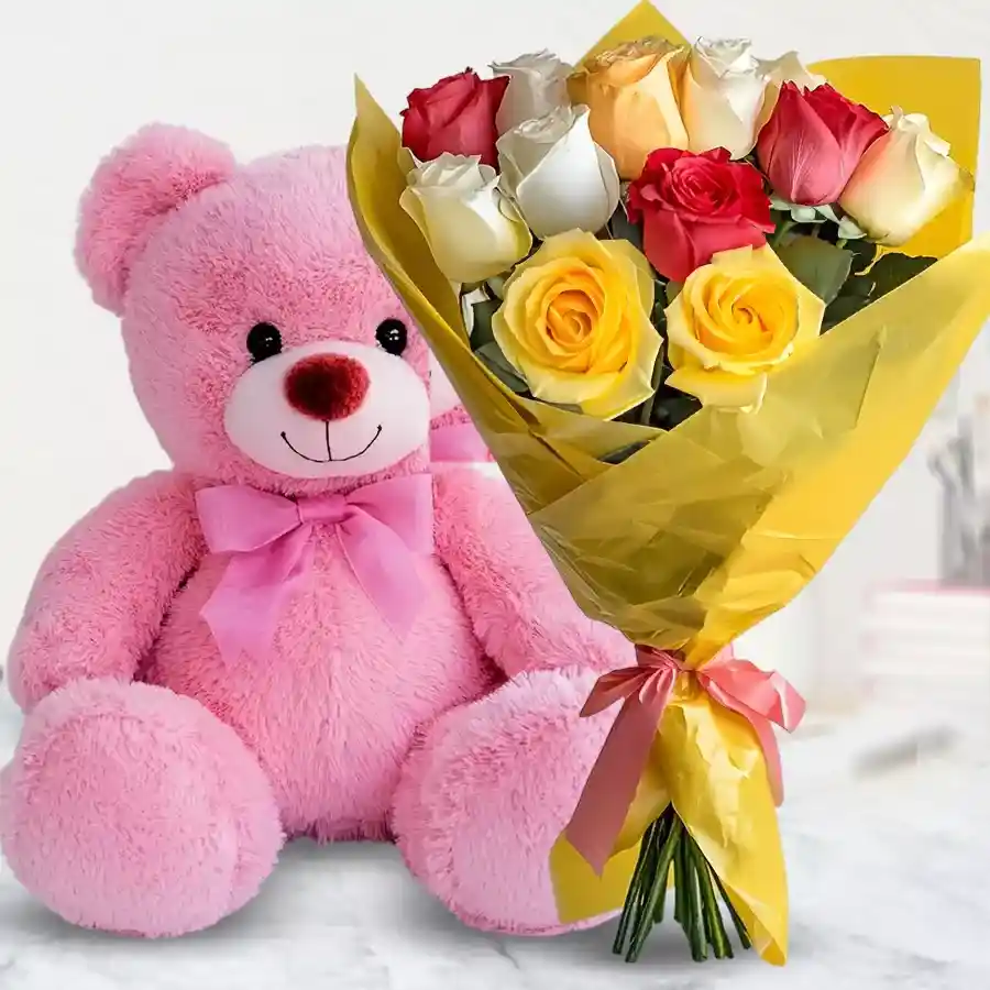 Mixed roses bouquet featuring assorted colors alongside a cute pink teddy bear.
