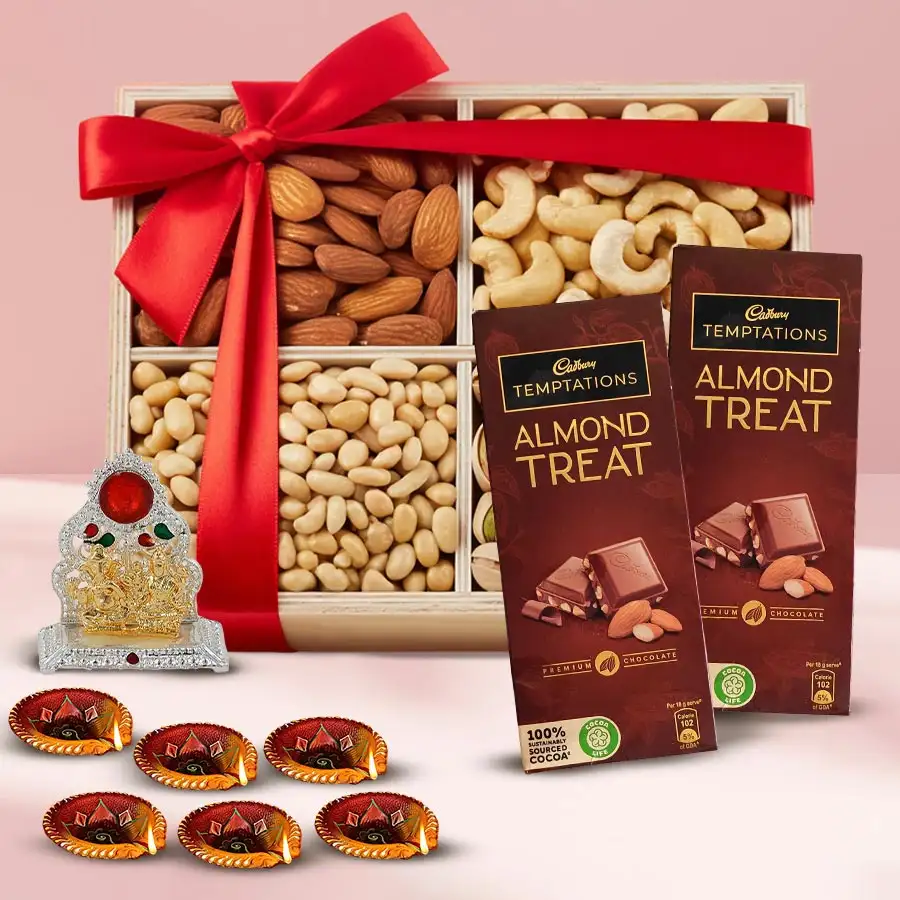 Wooden tray with salted dry fruits, Cadbury chocolates, Ganesh Laxmi Mandap, and diyas for Diwali celebration.