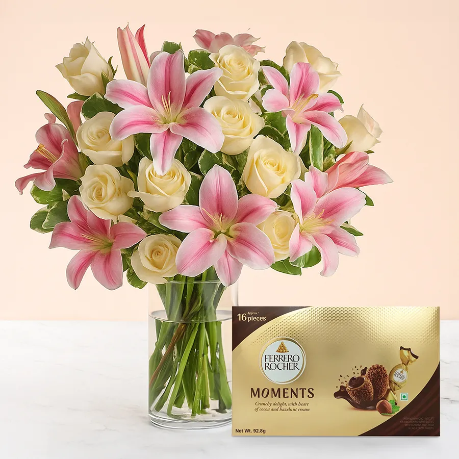 Blissful Blooms featuring pink lilies, white roses, and Ferrero Rocher chocolates in a glass vase.