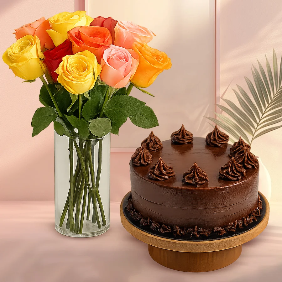 Bouquet of mixed roses in a glass vase with a chocolate cake.