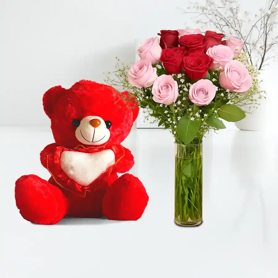 Lush Love in Glass Elegance arrangement with pink and red roses, gypsophila, and a 6-inch teddy bear in a glass vase.
