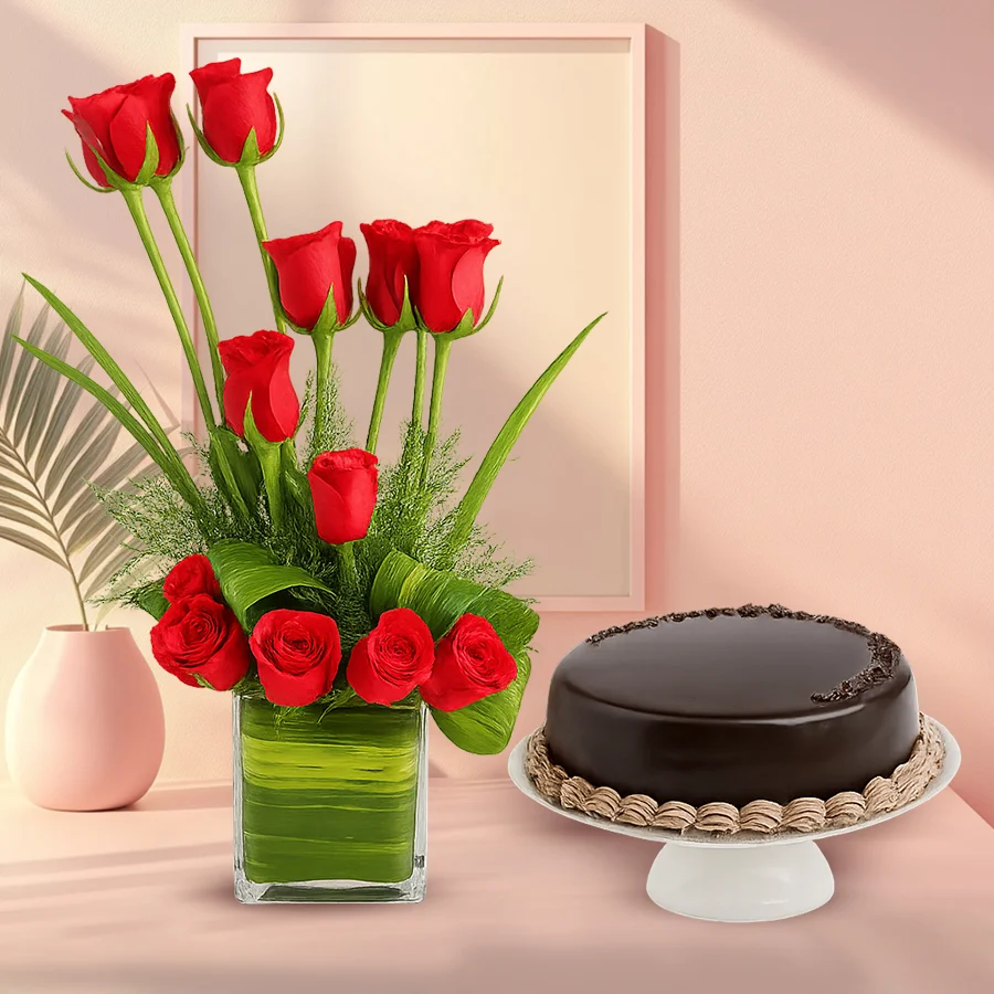 Chocolate cake and red roses arranged in a glass vase.