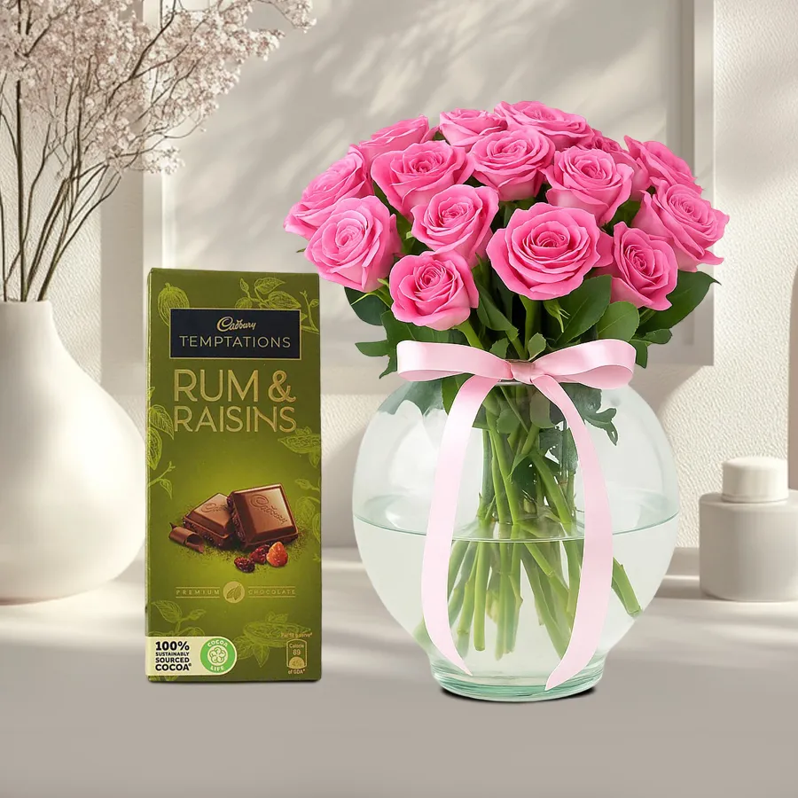 Romantic gift combo with 10 pink roses in a glass vase and Cadbury Temptations Rum N Raisins chocolates.