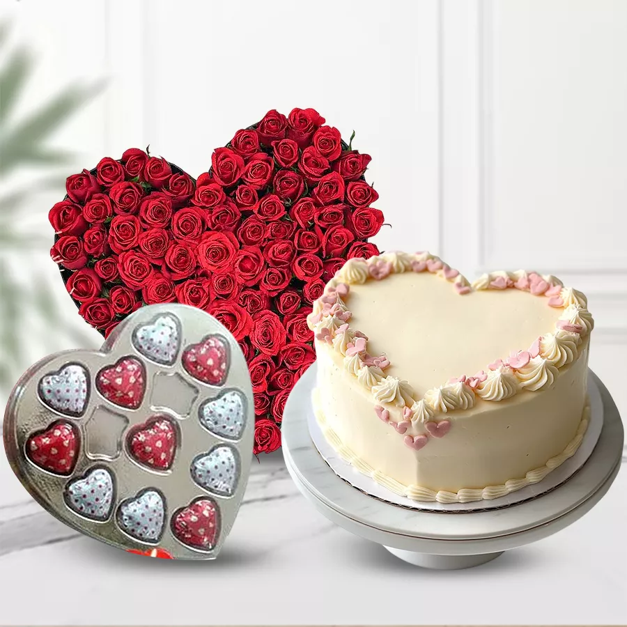 Heart-shaped gift combo featuring 24 red roses, chocolates, and a cake.