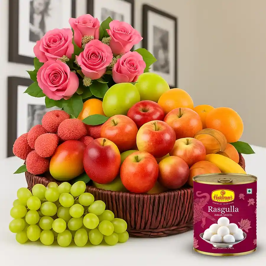 A beautiful gift basket featuring fresh fruits, Haldiram's Rasgulla, and pink roses, perfect for celebrating mom.