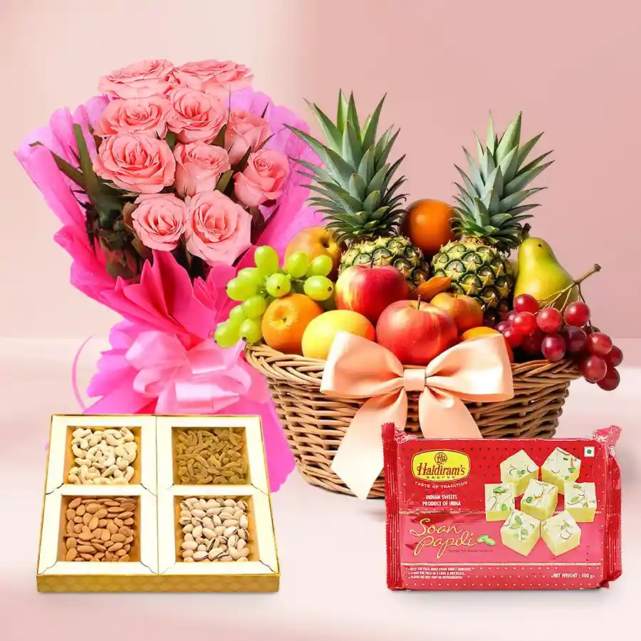 A vibrant basket featuring fresh seasonal fruits, dry fruits, Haldirams Soan Papdi, and a bouquet of pink roses for Mother's Day.