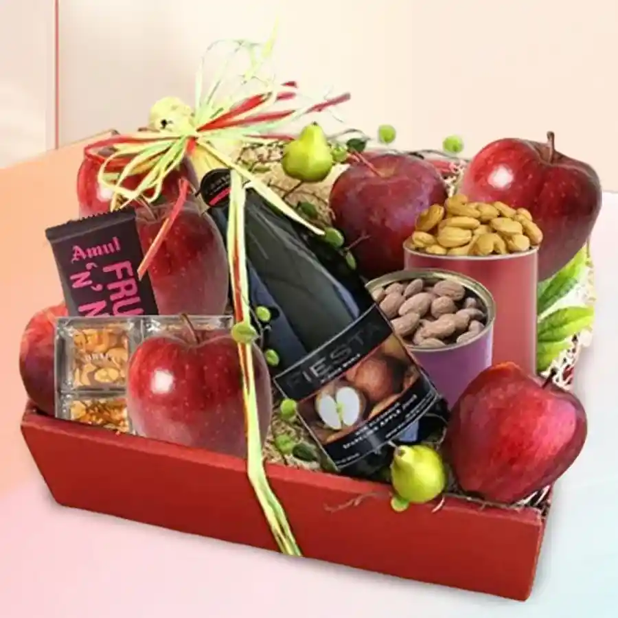 A beautifully arranged Mother’s Day fruit tray with fresh apples, sparkling juice, nuts, and chocolate in a wooden tray.