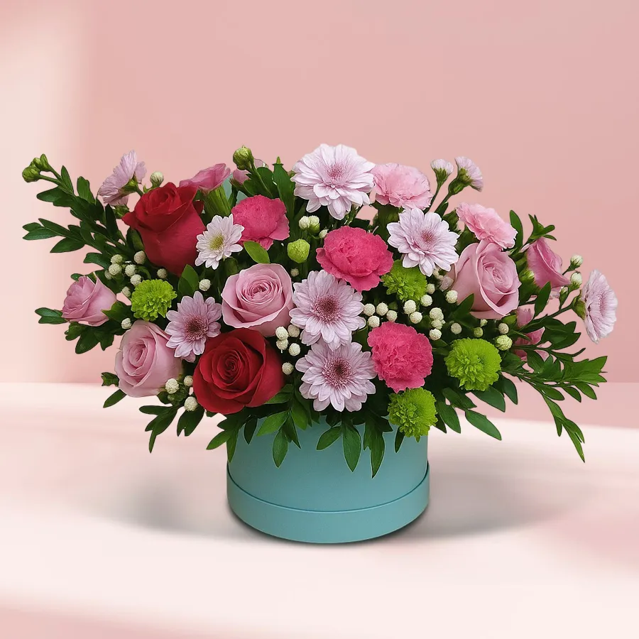Enigmatic Floral Harmony Delight featuring red roses, pink roses, pink carnations, and gerberas in a blue round box.