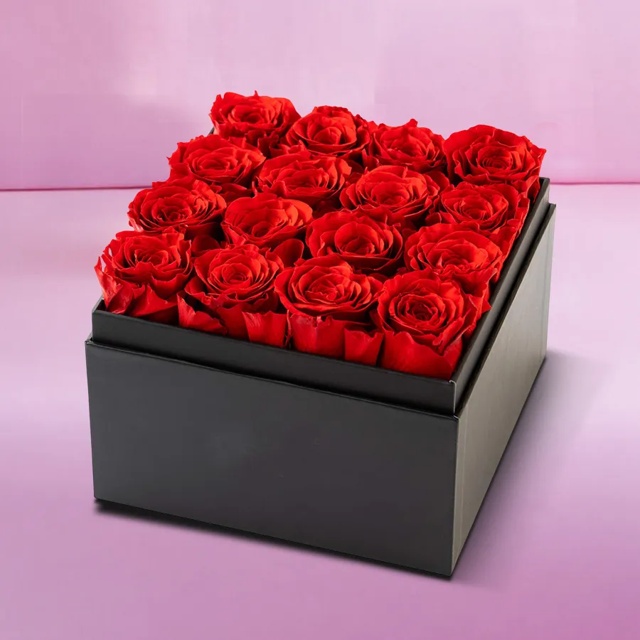 A stunning arrangement of 16 pink roses in a sleek black cardboard gift box, perfect for gifting.