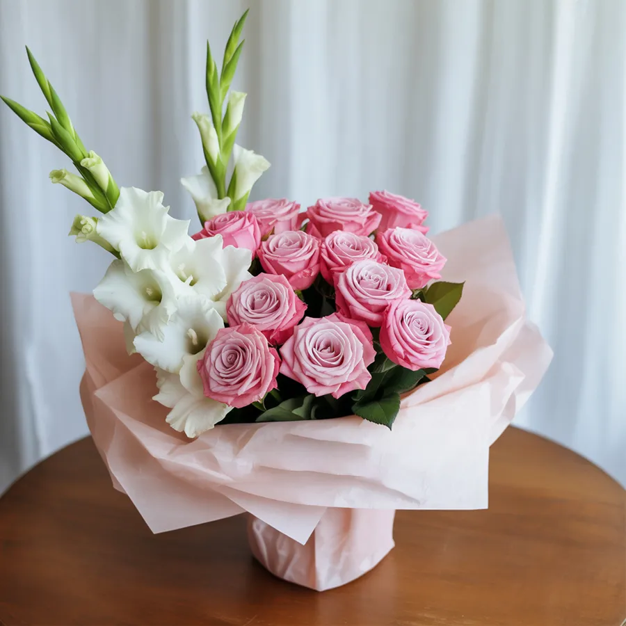 A charming bouquet featuring 12 pink roses and 7 white gladiolus wrapped in tissue, symbolizing elegance and heartfelt sentiments.